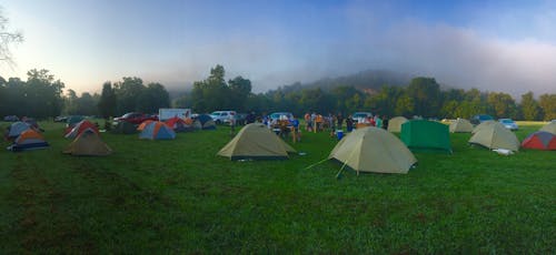 Tents on Green Grass Field Near Mountain