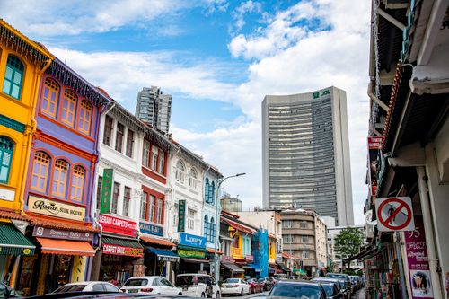 Free Explore vibrant colonial architecture with colorful buildings along a bustling Singapore street under a clear blue sky. Stock Photo