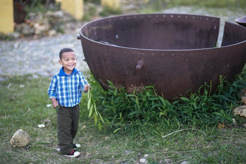 Happy Kid beside a Rusty Basin 