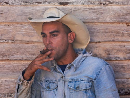 Free Man in Denim Shirt Smoking Cigar Stock Photo