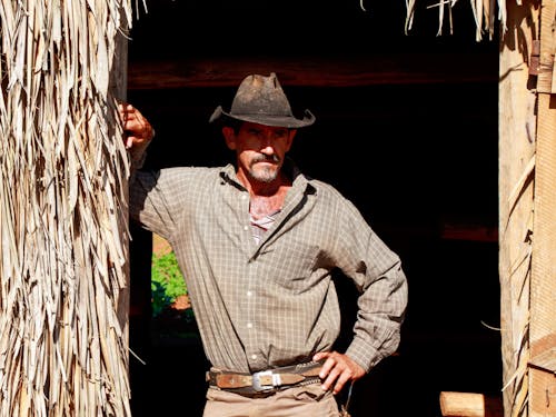 A Man in Black Cowboy Hat Standing on the Doorway