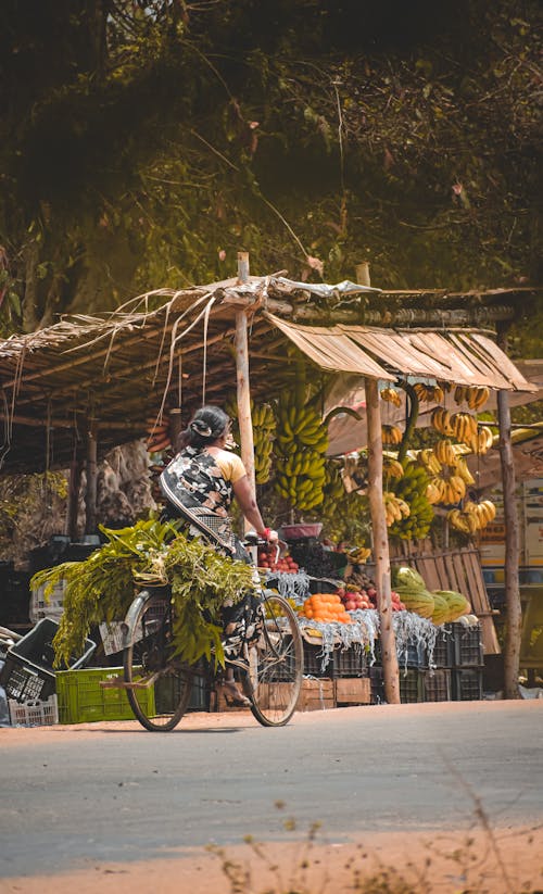 Woman Riding a Bike while Bringing Plants