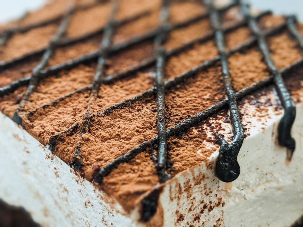 A Delicious White Cake Topped with Chocolate Powder and Syrup