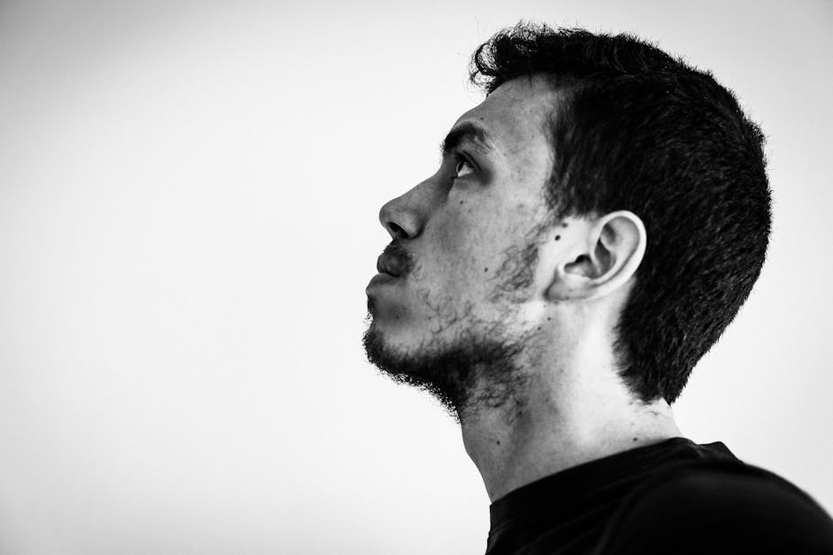 Contrasting black and white side view portrait of a contemplative young man.