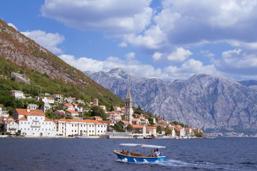 Explore the picturesque town of Perast with stunning mountains and a boat on the bay.