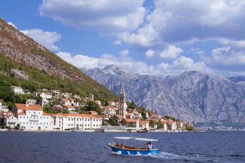 Free Explore the picturesque town of Perast with stunning mountains and a boat on the bay. Stock Photo