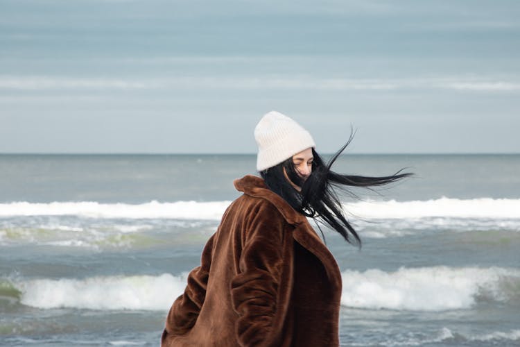 Woman In Coat And Hat Against Sea