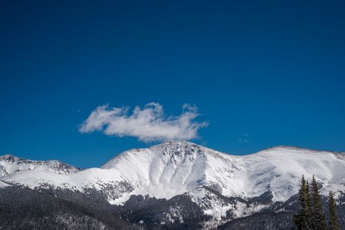 Free Majestic snow-covered mountain peak beneath a crisp blue sky, perfect for nature or travel themes. Stock Photo