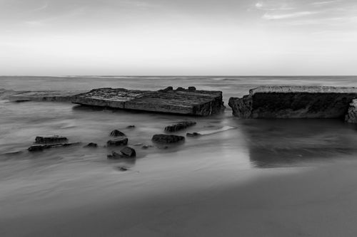Free Serene black and white ocean view with rocks and smooth waves, capturing the essence of tranquility. Stock Photo