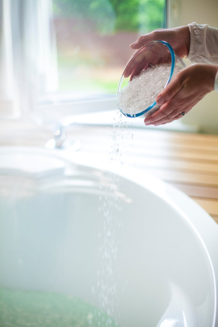 Woman Putting Bath Salt In The Bathtub 