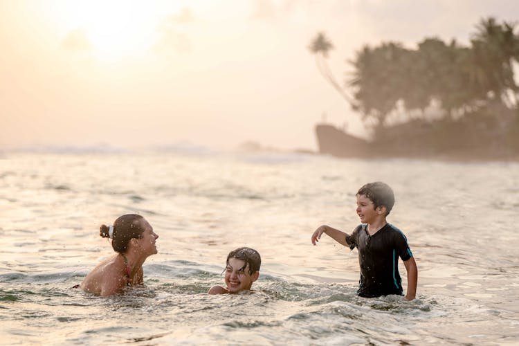 A Family Swimming On The Beach