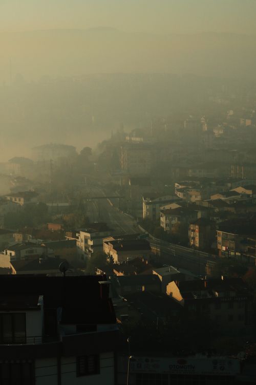 Free Aerial view of a foggy cityscape shrouded in smog, showcasing dense urban architecture. Stock Photo