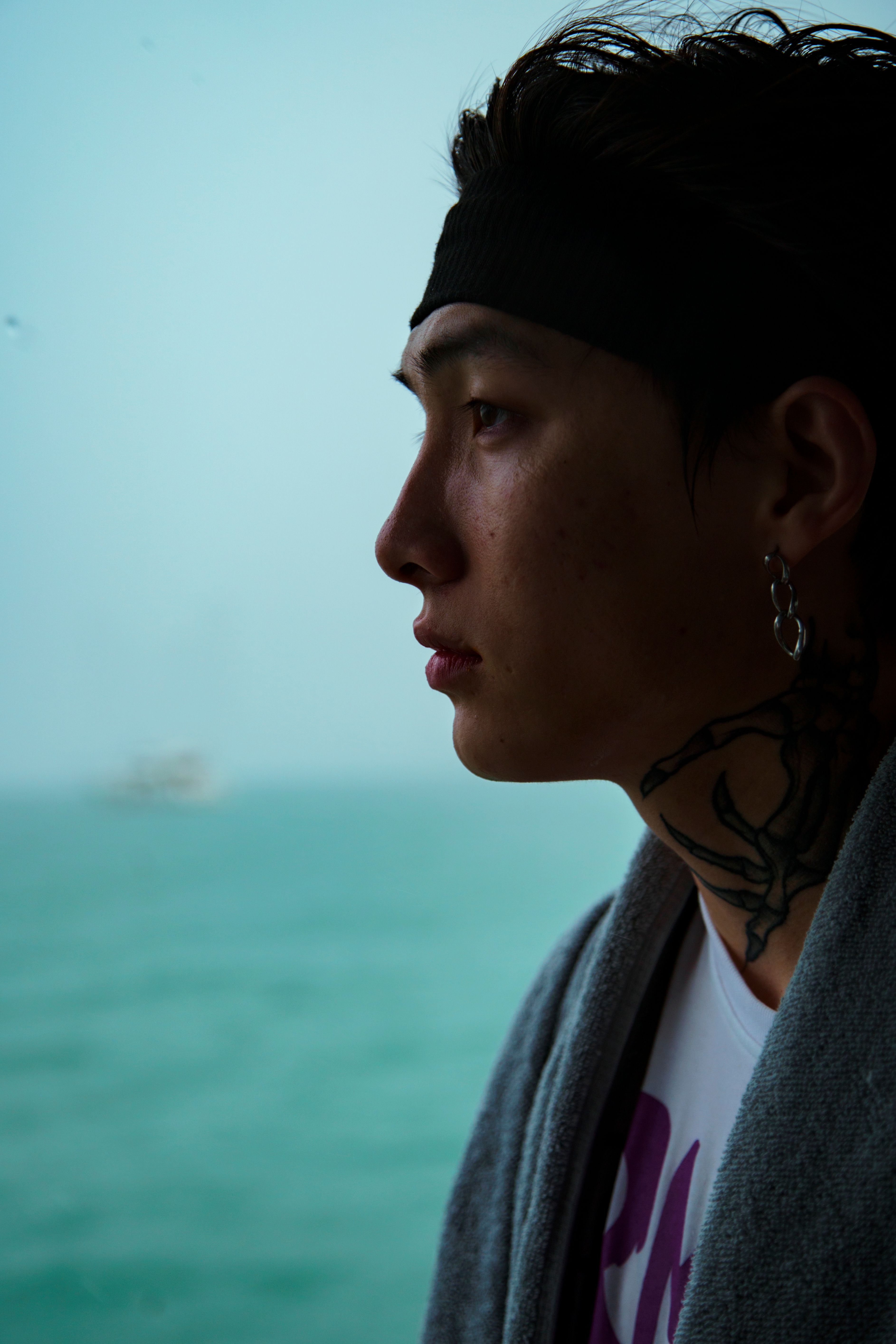 A thoughtful portrait of a young man by the Dubai shore, showcasing a serene and contemplative mood.
