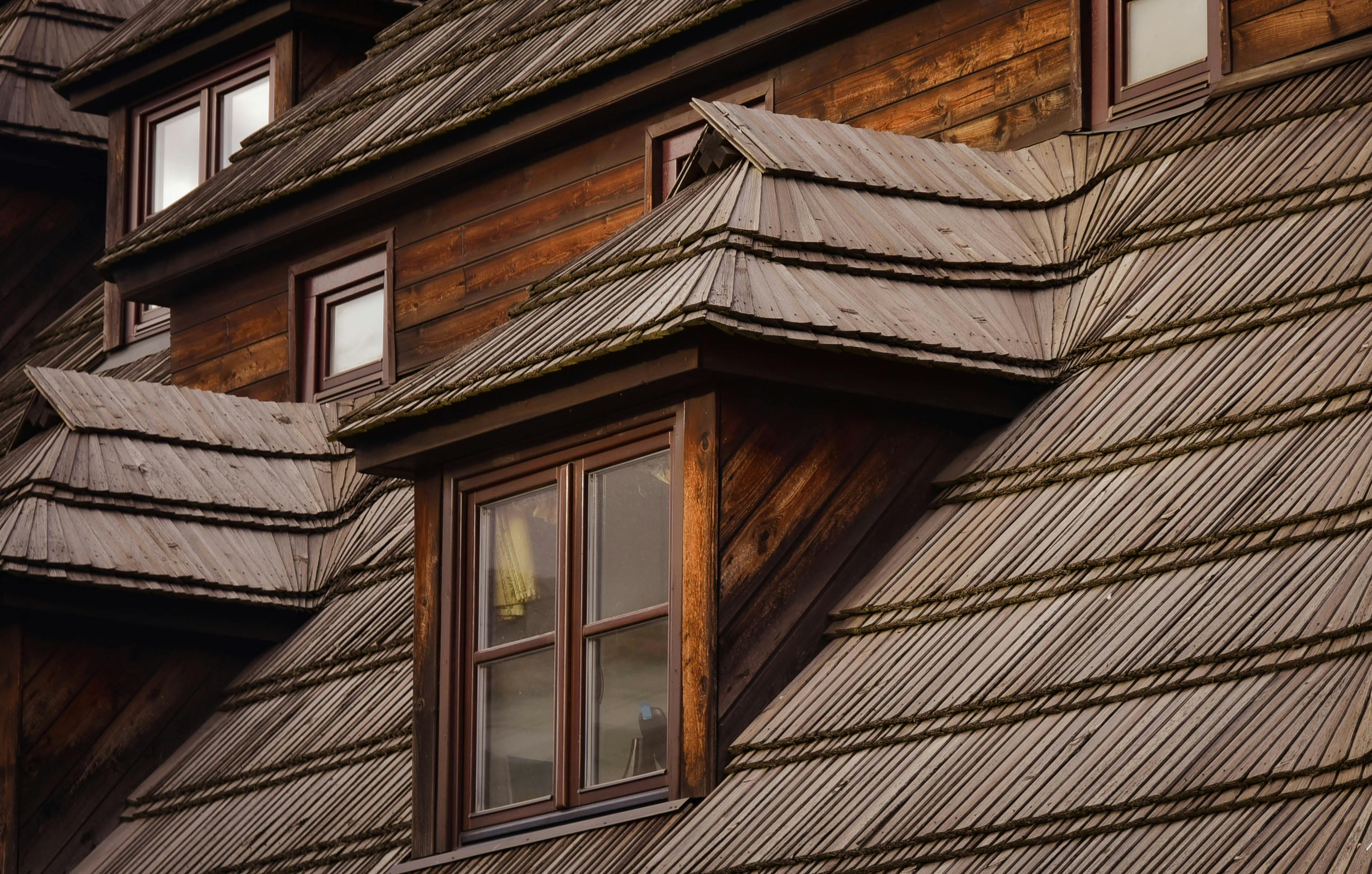 Close-up of rustic wooden house with detailed wooden roof tiles and windows. Architectural beauty.