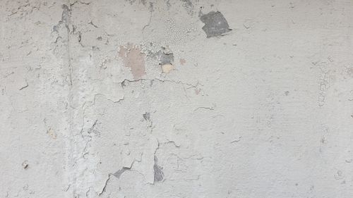 Free Detailed view of an old concrete wall with peeling paint and cracks, perfect for texture background. Stock Photo
