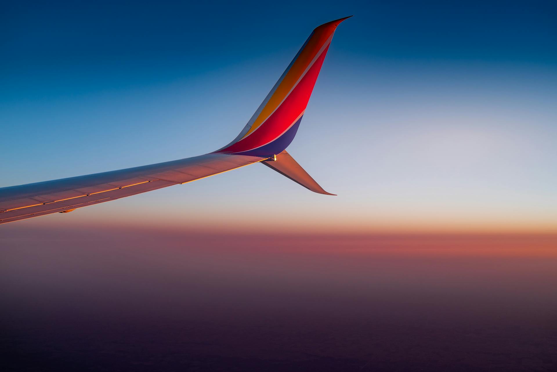 A stunning view from an airplane wing with a colorful sunset sky. Perfect for travel and aviation themes.