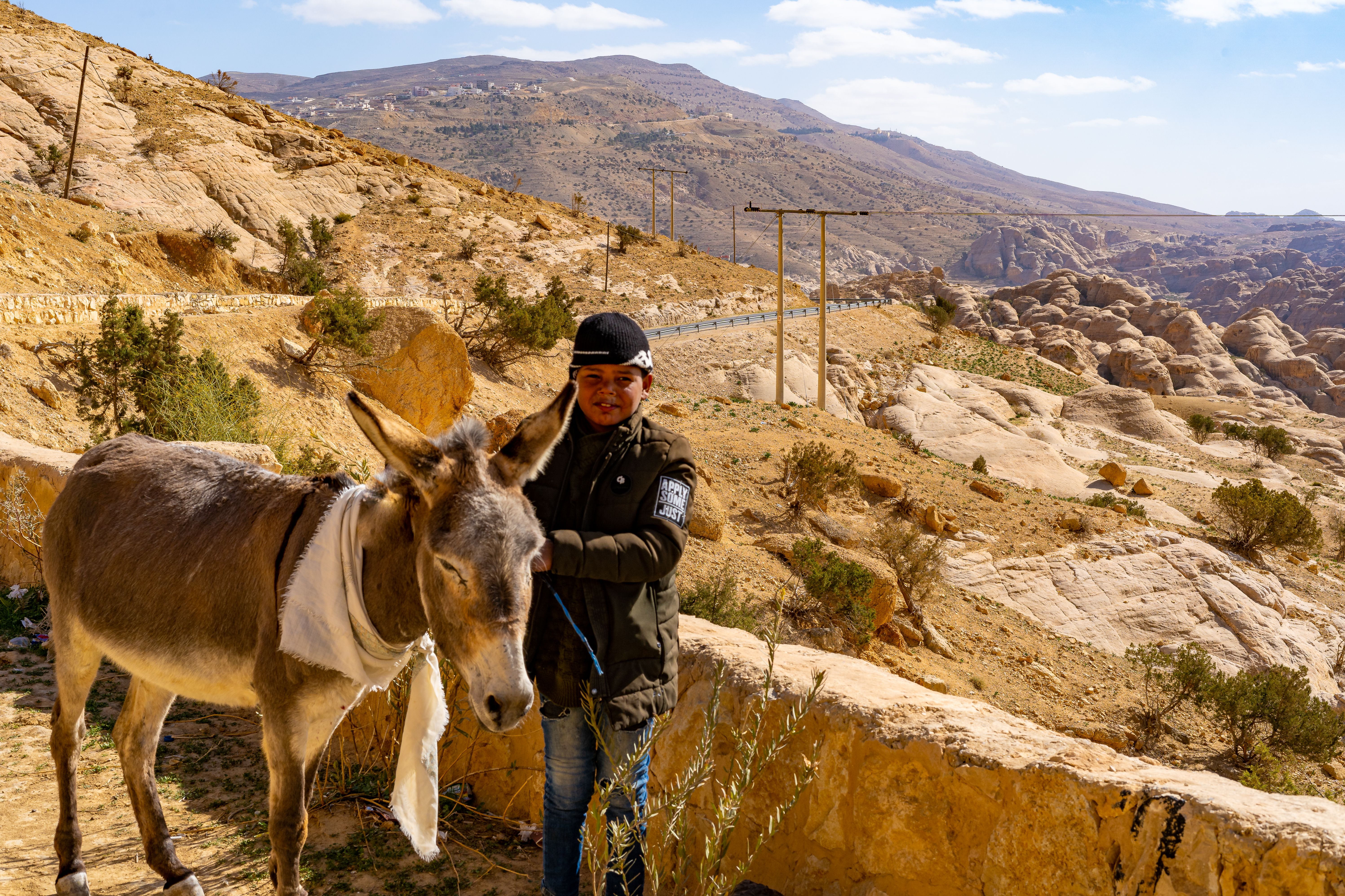 A child and donkey in the rugged terrain of Wadi Musa, Jordan.