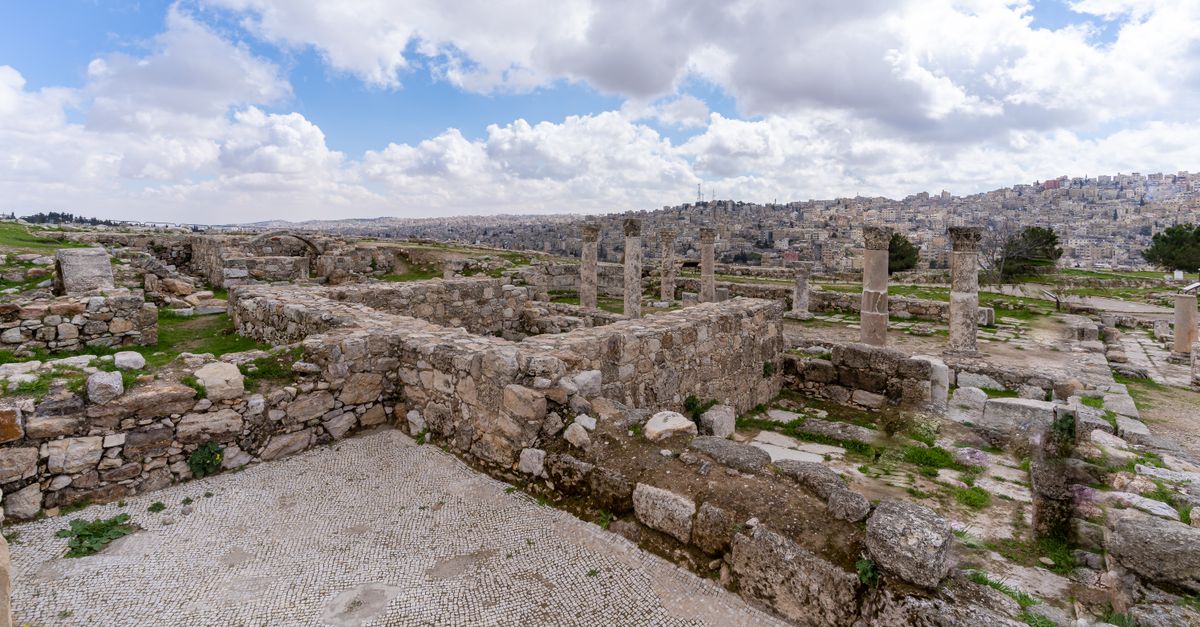 Visitors explore a historic stone building at the Beit Jaddi Rabah heritage site overlooking the hills of Al-Shoubak, Jordan.