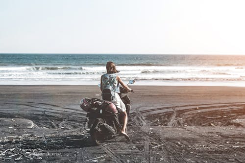 Woman Riding Motor Scooter on Seashore