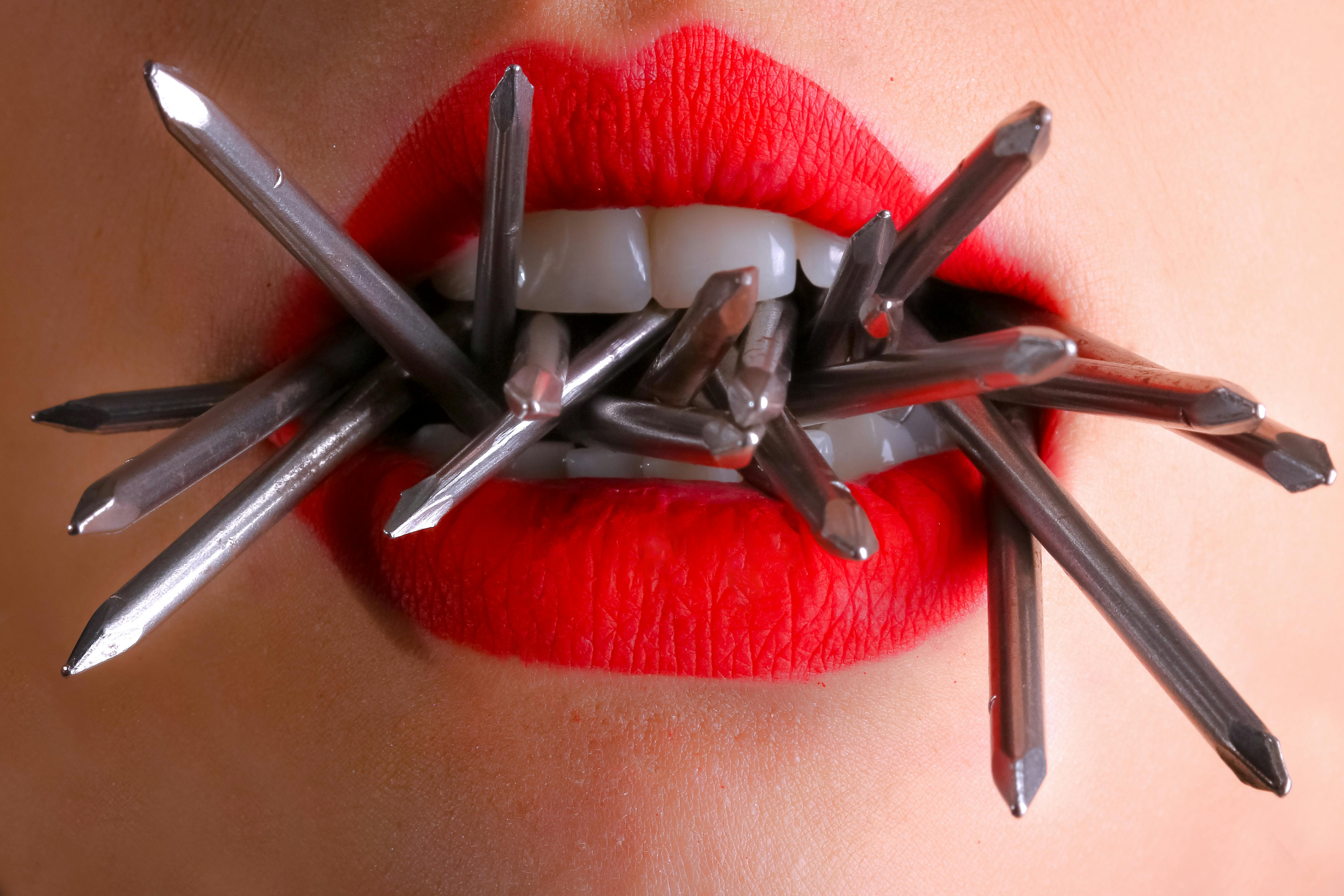 woman biting gray nails in her mouth