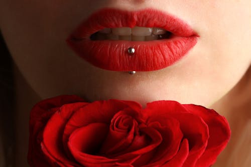無料 赤いバラの近くに赤い口紅を着ている女性 写真素材