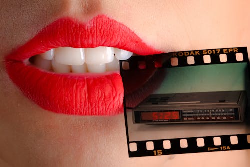 Person Wearing Red Lipstick Biting Film