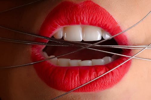 一個女人用他的嘴上的灰色電纜的特寫照片