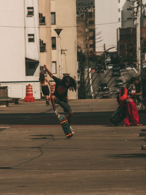 Free Dynamic capture of a skateboarder performing a trick in a bustling cityscape. Stock Photo