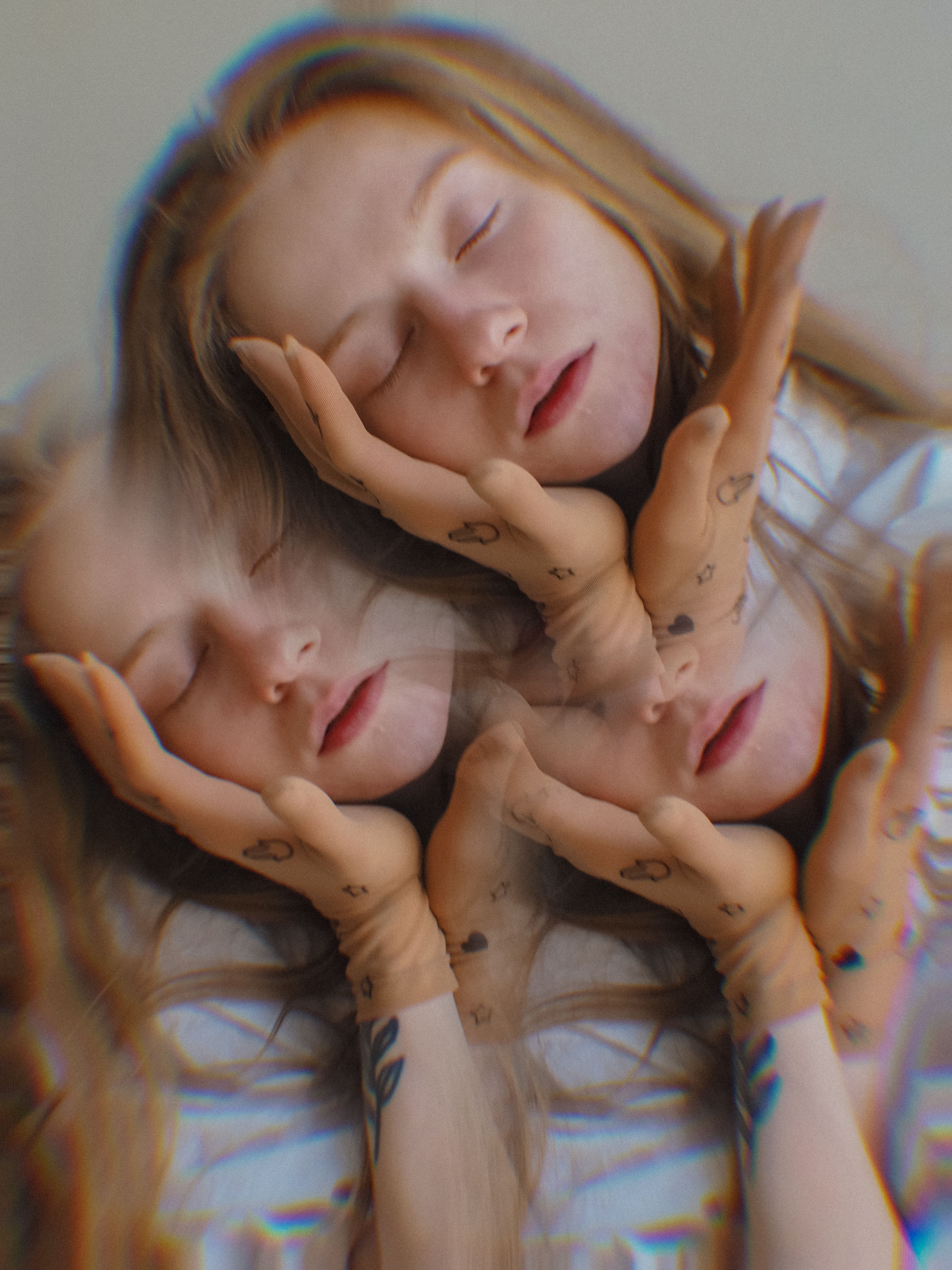 Creative triple exposure portrait of a woman with eyes closed and hand tattoos, evoking a dreamy mood.