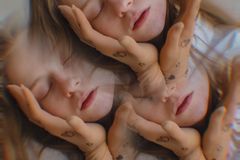Creative triple exposure portrait of a woman with eyes closed and hand tattoos, evoking a dreamy mood.