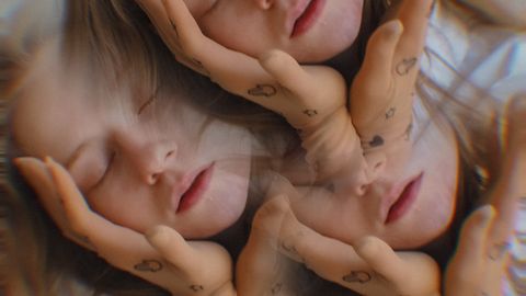 Creative triple exposure portrait of a woman with eyes closed and hand tattoos, evoking a dreamy mood.