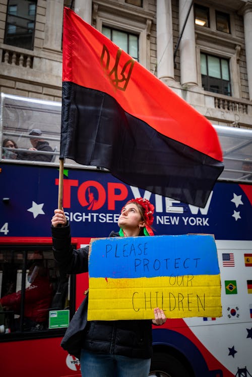 Woman Holding Flag and Banners of Ukraine and Ukrainian Insurgent Army