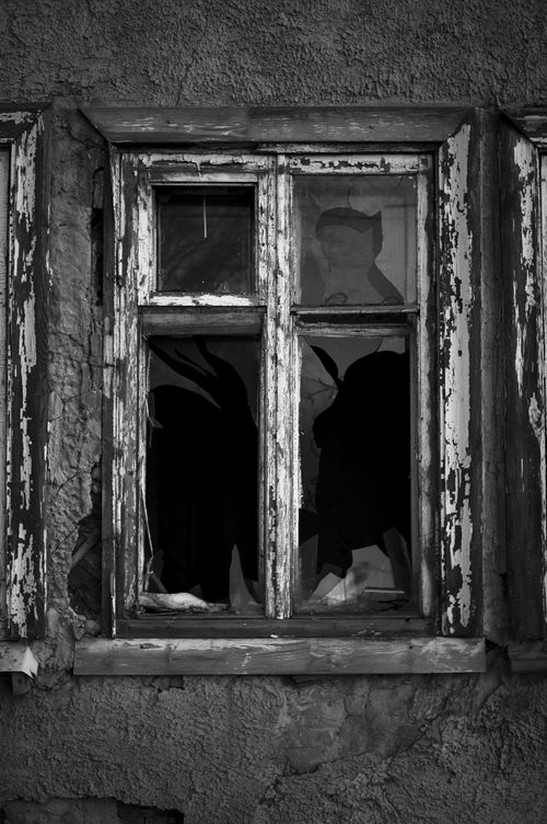Free Black and white image of a broken window in an old, weathered building. Stock Photo
