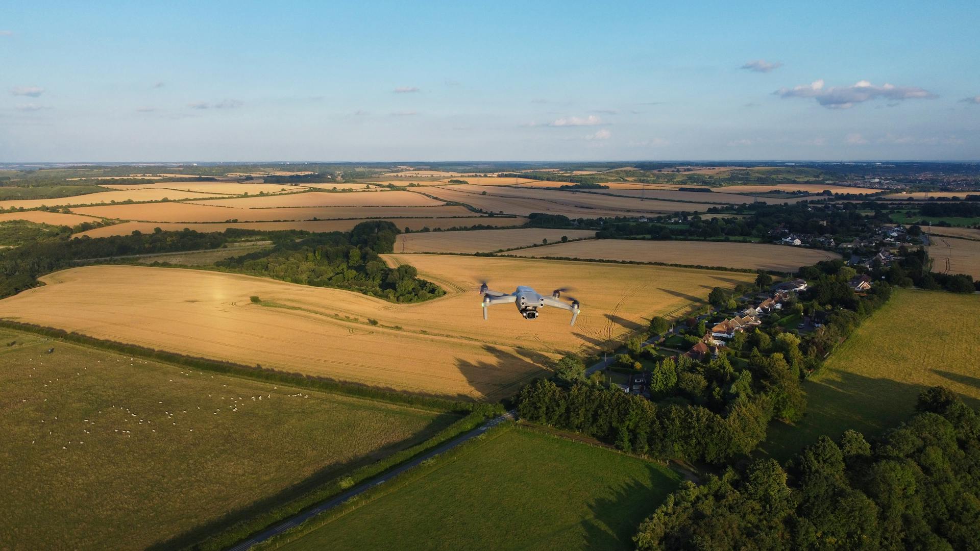 Aerial view of drone flying over lush English farmlands during summer, capturing scenic landscapes.