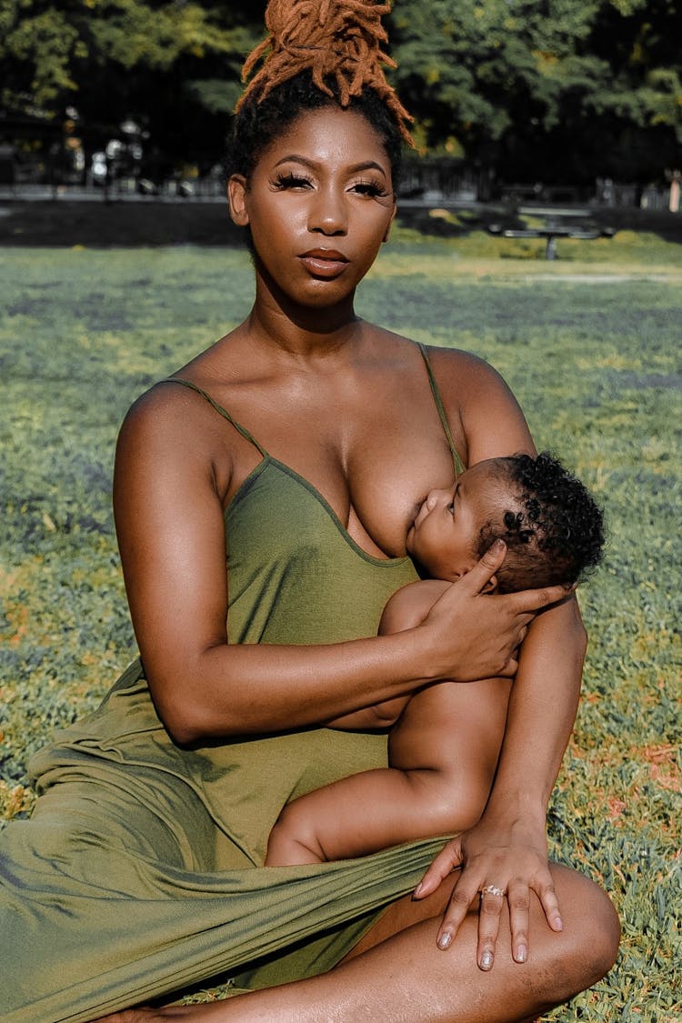 Mother Breastfeeding Her Child In Park