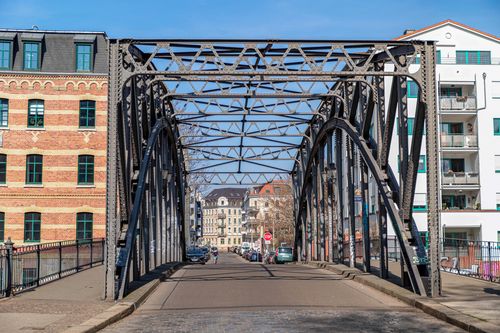 Free View of the historic Konneritz Bridge in Leipzig, showcasing intricate metalwork and surrounding architecture. Stock Photo