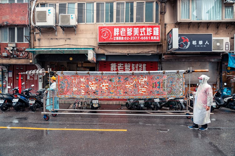 Men On Street With Trailer With Fabric With Pattern