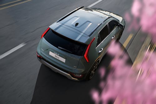 Free High Angle View of a Car on a Road and Blurred Blossoming Tree Stock Photo