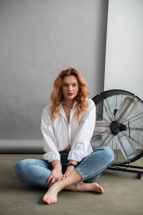 Photo of Redhead Young Woman Sitting Cross Legged on Floor