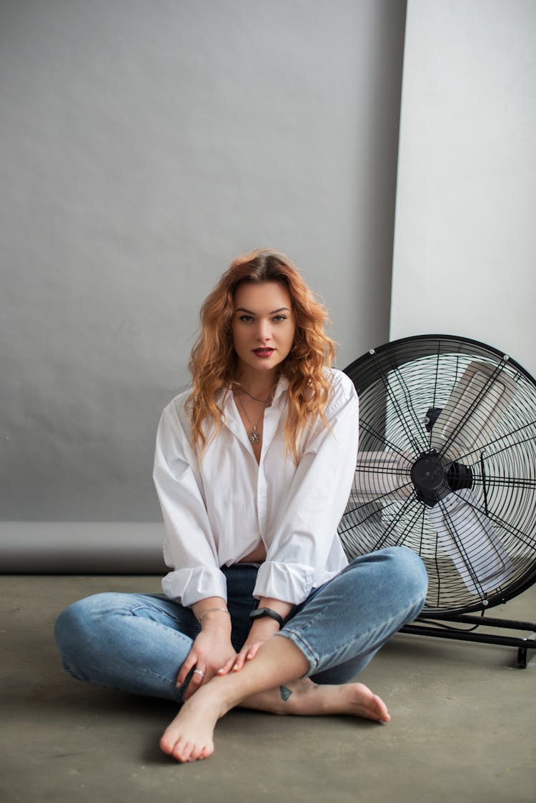 Photo Of Redhead Young Woman Sitting Cross Legged On Floor