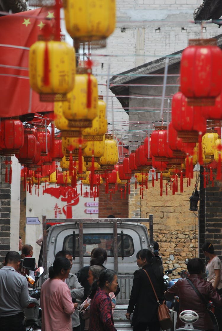 Chinese Lanterns Hanging Over The Busy Street With People Walking