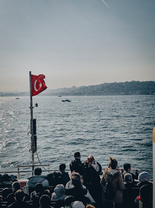 People Riding a Boat with a Turkish Flag