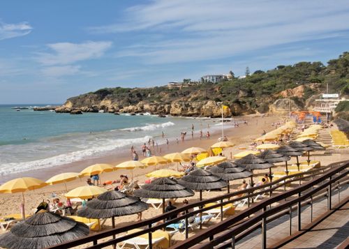 Free A vibrant beach scene in Albufeira, Portugal, featuring sunbathers and umbrellas. Stock Photo