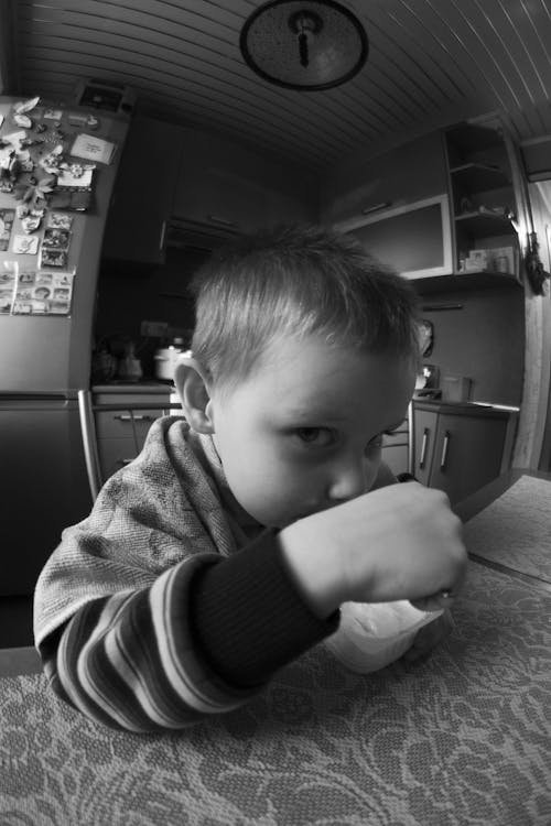 Free Grayscale Photo of a Boy Eating Stock Photo