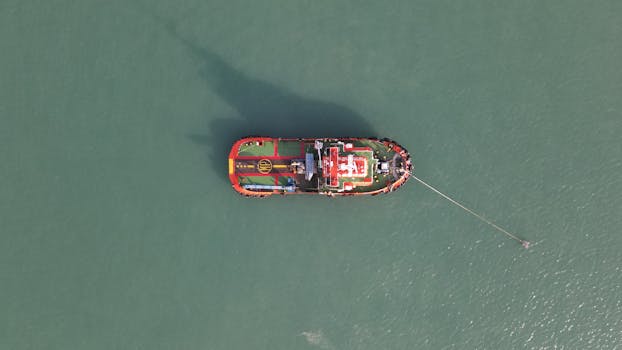 Aerial view of a colorful boat anchored in the calm waters of Port Dickson, Malaysia.