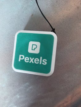 Close-up of a green Pexels logo on a white square background, symbolizing media and creativity.