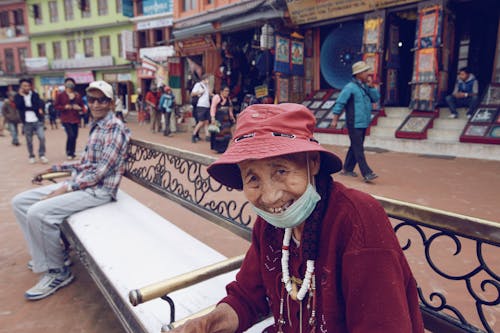 Smiling Elderly Man and Woman Sitting on a Bench 