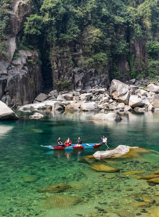 Free People Riding a Boat on the River Near the Rock Formation Stock Photo