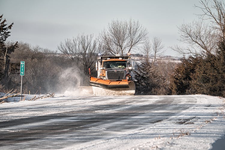 Yellow Truck Sweeping Of The Snow On The Road