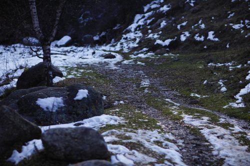 Free A scenic winter pathway with patches of melting snow and natural rocks. Stock Photo